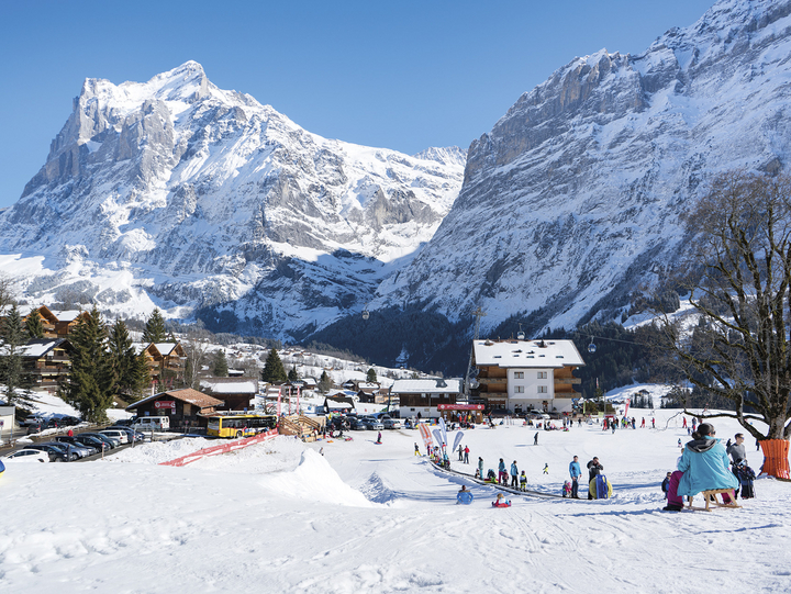 Impressive mountains loom in the background while guests learn and play on the beginner ski slope and sled track at the Bodmi Arena