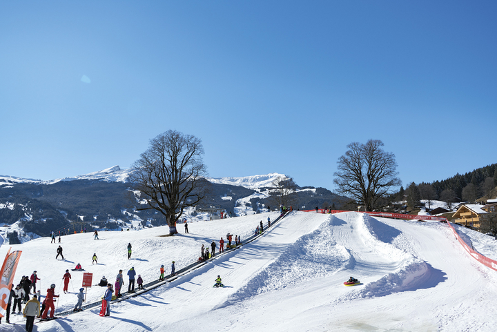 Guests use the magic carpet for easy access to the top of the beginner ski slope and sled track at the Bodmi Arena